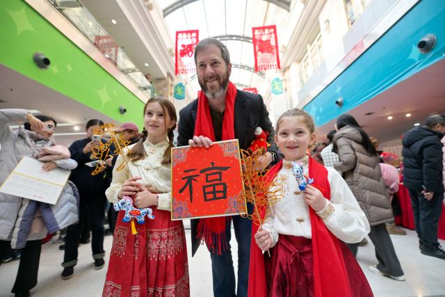 (260124) -- TIANJIN, Jan. 24, 2026 (Xinhua) -- Tourists pose for photos during a temple fair for children in north China's Tianjin, on Jan. 24, 2026. A special temple fair tailored for children kicked off in north China's Tianjin on Saturday. Crowds of parents and kids gathered at the fair to experience the festive atmosphere ahead of the Spring Festival. The event features a variety of activities including traditional handicraft making, Tianjin-style food tasting, and interactive games. (Xinhua/Zhao Zishuo)