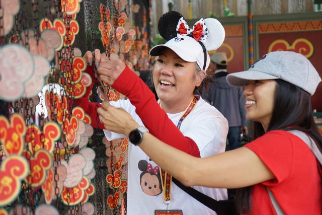(260124) -- ANAHEIM, Jan. 24, 2026 (Xinhua) -- Visitors make wishes in front of the "Wishing Wall" at Disney California Adventure Park in Anaheim, California, the United States, Jan. 23, 2026. Disneyland Resort kicked off its annual Lunar New Year celebrations on Friday, transforming the park into a vibrant showcase of Asian cultures, cuisine and traditions that continues to attract growing interest from U.S. visitors.
   TO GO WITH "Feature: Disneyland's Lunar New Year celebrations offer immersive window into Asian cultures" (Photo by Zeng Hui/Xinhua)