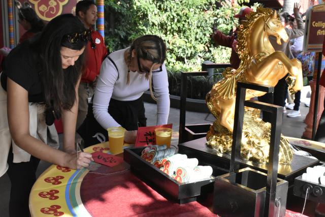 (260124) -- ANAHEIM, Jan. 24, 2026 (Xinhua) -- Visitors write their New Year wishes on wishing cards at Disney California Adventure Park in Anaheim, California, the United States, Jan. 23, 2026. Disneyland Resort kicked off its annual Lunar New Year celebrations on Friday, transforming the park into a vibrant showcase of Asian cultures, cuisine and traditions that continues to attract growing interest from U.S. visitors.
   TO GO WITH "Feature: Disneyland's Lunar New Year celebrations offer immersive window into Asian cultures" (Xinhua/Gao Shan)