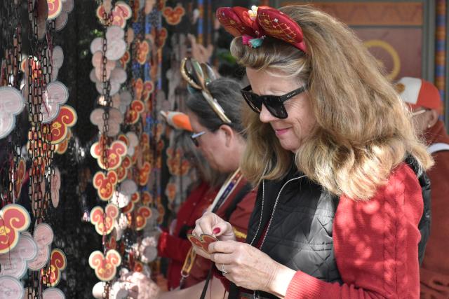 (260124) -- ANAHEIM, Jan. 24, 2026 (Xinhua) -- A visitor makes wishes in front of the "Wishing Wall" at Disney California Adventure Park in Anaheim, California, the United States, Jan. 23, 2026. Disneyland Resort kicked off its annual Lunar New Year celebrations on Friday, transforming the park into a vibrant showcase of Asian cultures, cuisine and traditions that continues to attract growing interest from U.S. visitors.
   TO GO WITH "Feature: Disneyland's Lunar New Year celebrations offer immersive window into Asian cultures" (Xinhua/Gao Shan)