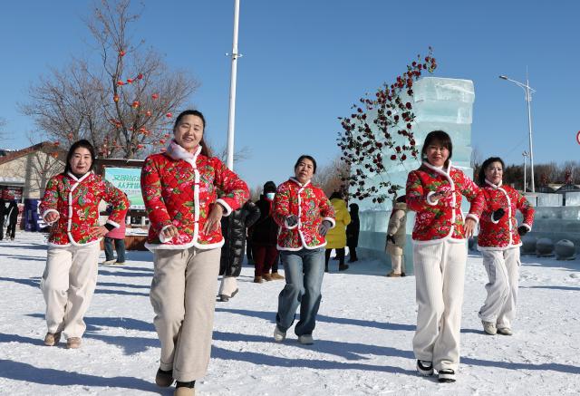 (260124) -- SHENYANG, Jan. 24, 2026 (Xinhua) -- People are seen dancing during a winter fishing event at Wolong Lake in Kangping County of Shenyang, northeast China's Liaoning Province, Jan. 24, 2026. A winter fishing event began here on Saturday, featuring performances, fish cuisine, and ice and snow recreational facilities. (Xinhua/Li Gang)