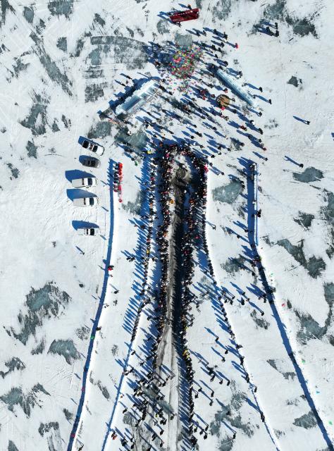 (260124) -- SHENYANG, Jan. 24, 2026 (Xinhua) -- An aerial drone photo taken on Jan. 24, 2026 shows people watching a fish-catching activity at Wolong Lake in Kangping County of Shenyang, northeast China's Liaoning Province. A winter fishing event began here on Saturday, featuring performances, fish cuisine, and ice and snow recreational facilities. (Xinhua/Li Gang)