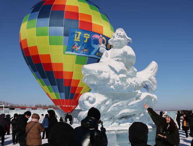 (260124) -- SHENYANG, Jan. 24, 2026 (Xinhua) -- Tourists take photos of an ice sculpture during a winter fishing event at Wolong Lake in Kangping County of Shenyang, northeast China's Liaoning Province, Jan. 24, 2026. A winter fishing event began here on Saturday, featuring performances, fish cuisine, and ice and snow recreational facilities. (Xinhua/Li Gang)