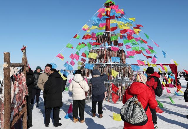 (260124) -- SHENYANG, Jan. 24, 2026 (Xinhua) -- Tourists visit a winter fishing event at Wolong Lake in Kangping County of Shenyang, northeast China's Liaoning Province, Jan. 24, 2026. A winter fishing event began here on Saturday, featuring performances, fish cuisine, and ice and snow recreational facilities. (Xinhua/Li Gang)