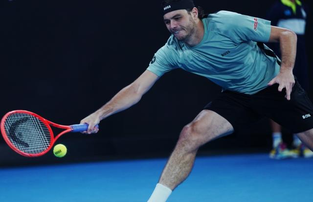 (260124) -- MELBOURNE, Jan. 24, 2026 (Xinhua) -- Taylor Fritz hits a return during the men's singles 3rd round match between Taylor Fritz of the United States and Stan Wawrinka of Switzerland at the Australian Open tennis tournament in Melbourne, Australia, Jan. 24, 2026. (Photo by Wang Shen/Xinhua)