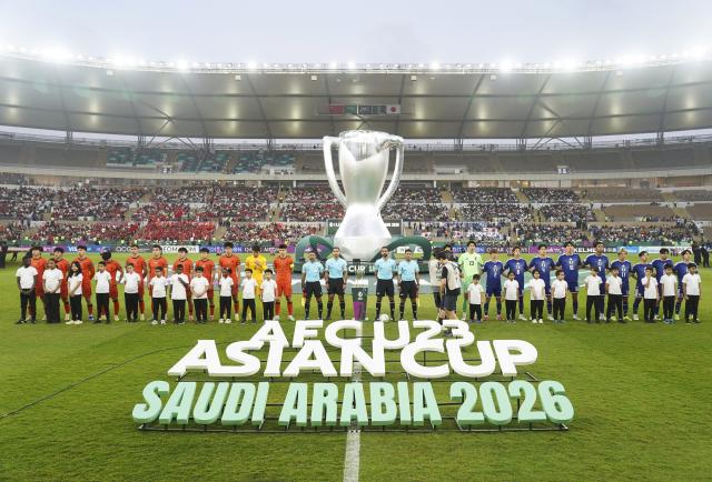 (260124) -- JEDDAH, Jan. 24, 2026 (Xinhua) -- Starting players and referees pose for photos before the 2026 AFC U23 Asian Cup final match between China and Japan in Jeddah, Saudi Arabia, Jan. 24, 2026. (Xinhua/Wang Haizhou)