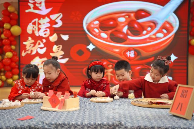 (260125) -- BEIJING, Jan. 25, 2026 (Xinhua) -- Children learn to make Laba garlic, a vinegar-preserved green and slightly spicy dish, at a kindergarten in Neiqiu County of Xingtai, north China's Hebei Province, Jan. 23, 2026. Various activities were held across the country to welcome the upcoming Laba Festival that falls on Jan. 26 this year. (Photo by Liu Jidong/Xinhua)