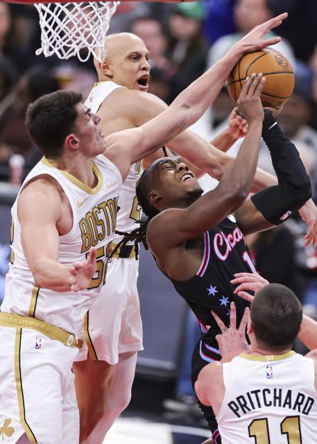 (260125) -- CHICAGO, Jan. 25, 2026 (Xinhua) -- Chicago Bulls' Ayo Dosunmu (R) is defended by Boston Celtics' Luka Garza (L) and Jordan Walsh (top) during the 2025-2026 NBA regular season basketball game between Boston Celtics and Chicago Bulls in Chicago, the United States, Jan. 24, 2026. (Photo by Joel Lerner/Xinhua)