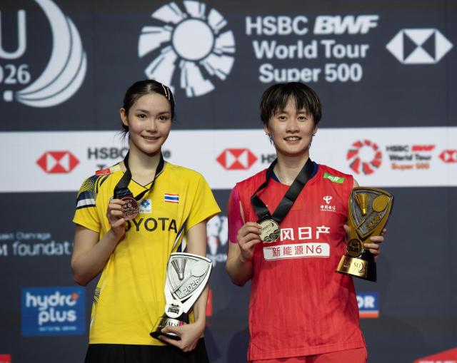 (260125) -- JAKARTA, Jan. 25, 2026 (Xinhua) -- Chen Yufei (R) and Pitchamon Opatniputh pose for photos during the awarding ceremony after the women's singles final match against Pitchamon Opatniputh of Thailand at the Indonesia Masters 2026 badminton tournament in Jakarta, Indonesia, Jan. 25, 2026. (Xinhua/Veri Sanovri)