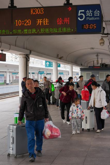 (260125) -- GUANGZHOU, Jan. 25, 2026 (Xinhua) -- Passengers prepare to board train K303 at Guangzhou Railway Station in Guangzhou, south China's Guangdong Province, Jan. 25, 2026. Train K303, the last conventional train departed here on Sunday, concluding the terminal operation of this kind of trains at the century-old station. (Xinhua/Wu Lu)