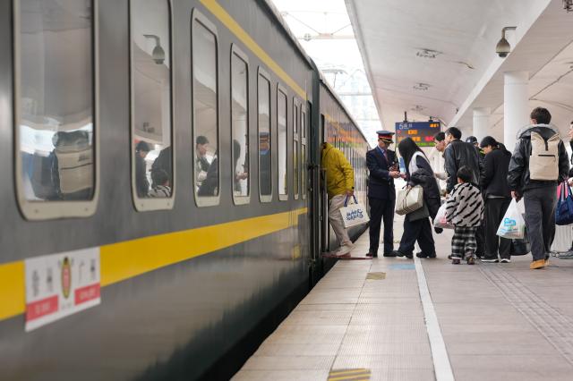 (260125) -- GUANGZHOU, Jan. 25, 2026 (Xinhua) -- Passengers board train K303 at Guangzhou Railway Station in Guangzhou, south China's Guangdong Province, Jan. 25, 2026. Train K303, the last conventional train departed here on Sunday, concluding the terminal operation of this kind of trains at the century-old station. (Xinhua/Wu Lu)