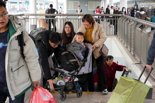 (260125) -- GUANGZHOU, Jan. 25, 2026 (Xinhua) -- Passengers prepare to board train K303 at Guangzhou Railway Station in Guangzhou, south China's Guangdong Province, Jan. 25, 2026. Train K303, the last conventional train departed here on Sunday, concluding the terminal operation of this kind of trains at the century-old station. (Xinhua/Wu Lu)