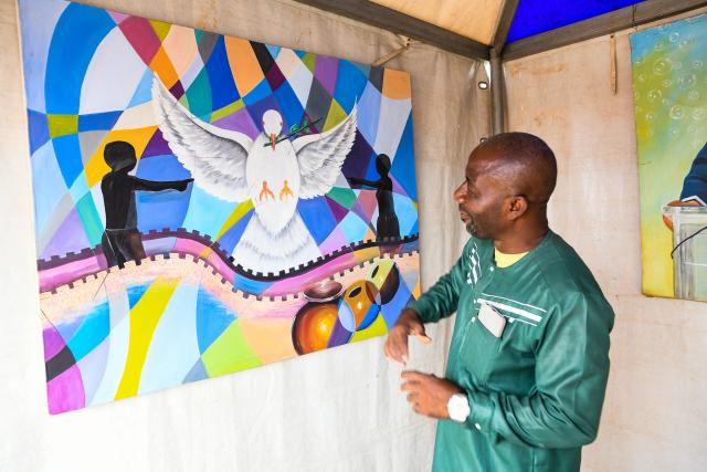 (260125) -- YAOUNDE, Jan. 25, 2026 (Xinhua) -- An artist introduces a painting during a celebration for the World Day for African and Afrodescendant Culture in Yaounde, Cameroon, Jan. 24, 2026. The World Day for African and Afrodescendant Culture was designated by the UNESCO in 2019 and is observed every year on Jan. 24. (Xinhua/Kepseu)