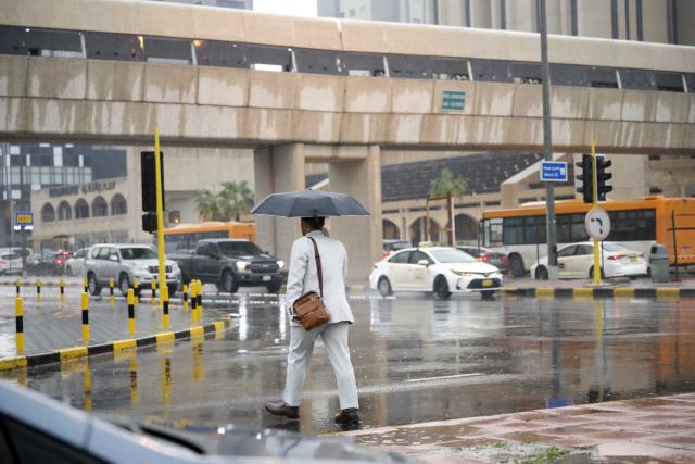 (260125) -- KUWAIT CITY, Jan. 25, 2026 (Xinhua) -- A man walks on a street during a rain in Kuwait City, Kuwait, on Jan. 25, 2026. Kuwait was hit on Sunday by sudden heavy rain, causing floods in parts of the country. (Photo by Asad/Xinhua)
