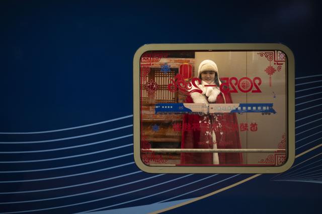 (260125) -- HARBIN, Jan. 25, 2026 (Xinhua) -- A staff member shows a costume for travel photography on the Train Y783 in northeast China's Heilongjiang Province, Jan. 25, 2026. Train Y783, a themed tourism train bound for Yabuli featuring travel photography services, was inaugurated Sunday in Harbin. It marks the company's first offering of its kind this year. Operated by China Railway Harbin Group Co., Ltd., the train allows passengers to dress in diverse costumes and avail themselves of photography services. (Xinhua/Zhang Tao)