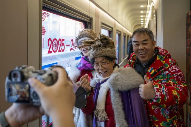 (260125) -- HARBIN, Jan. 25, 2026 (Xinhua) -- Passengers pose for photos on the Train Y783 in northeast China's Heilongjiang Province, Jan. 25, 2026. Train Y783, a themed tourism train bound for Yabuli featuring travel photography services, was inaugurated Sunday in Harbin. It marks the company's first offering of its kind this year. Operated by China Railway Harbin Group Co., Ltd., the train allows passengers to dress in diverse costumes and avail themselves of photography services. (Xinhua/Zhang Tao)
