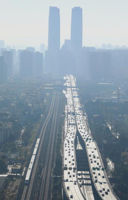 (260125) -- BEIJING, Jan. 25, 2026 (Xinhua) -- A bullet train (lower L) runs in the urban area of Kunming City, southwest China's Yunnan Province, Jan. 25, 2026. A new train schedule will be put into effect in China from Jan. 26. 2026. (Photo by Zheng Yi/Xinhua)