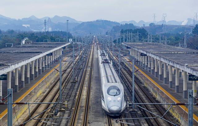 (260125) -- BEIJING, Jan. 25, 2026 (Xinhua) -- A bullet train runs past the Qianxi Railway Station in Qianxi, southwest China's Guizhou Province, Jan. 25, 2026. A new train schedule will be put into effect in China from Jan. 26. 2026. (Photo by Fan Hui/Xinhua)