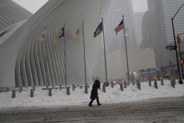 (260126) -- NEW YORK, Jan. 26, 2026 (Xinhua) -- A pedestrian walks past the World Trade Center subway station amid snow in New York, the United States, on Jan. 25, 2026. A historic winter storm is sweeping across the Midwest and eastern parts of the United States on Sunday, causing unprecedented travel chaos. (Xinhua/Zhang Fengguo)