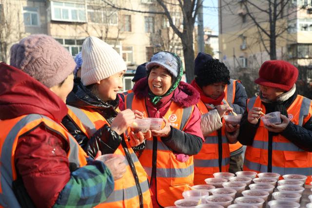(260126) -- BEIJING, Jan. 26, 2026 (Xinhua) -- Sanitation workers taste Laba porridge served by volunteers in Fengrun District of Tangshan, north China's Hebei Province, on Jan. 25, 2026. Various activities were held across the country to celebrate the Laba Festival that falls on Jan. 26 this year. (Photo by Zhu Dayong/Xinhua)