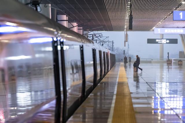 (260126) -- WUHAN, Jan. 26, 2026 (Xinhua) -- Passengers board train No. G340 at the Wuhan Railway Station in Wuhan, central China's Hubei Province, on Jan. 26, 2026. A new nationwide train schedule has taken effect in China from Jan. 26, 2026 with improved passenger and freight transport capacity and efficiency. (Xinhua/Wu Zhizun)