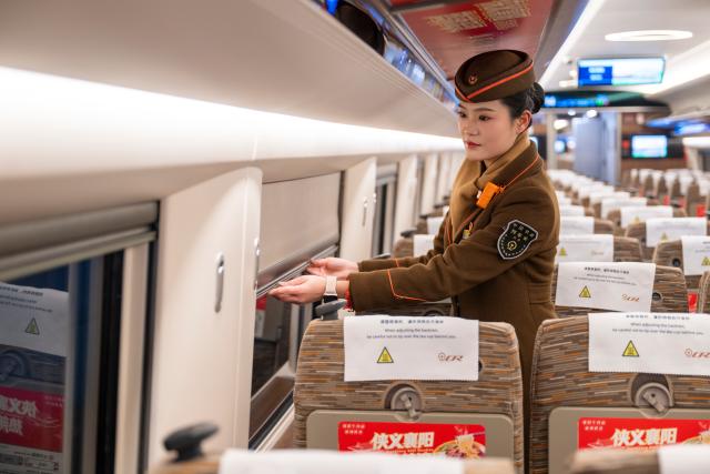 (260126) -- WUHAN, Jan. 26, 2026 (Xinhua) -- The conductor of train No. G340 prepares for departure at the Wuhan Railway Station in Wuhan, central China's Hubei Province, on Jan. 26, 2026. A new nationwide train schedule has taken effect in China from Jan. 26, 2026 with improved passenger and freight transport capacity and efficiency. (Xinhua/Wu Zhizun)