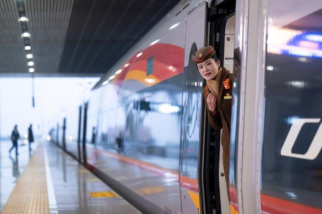 (260126) -- WUHAN, Jan. 26, 2026 (Xinhua) -- The conductor of train No. G340 prepares to close the train doors at the Wuhan Railway Station in Wuhan, central China's Hubei Province, on Jan. 26, 2026. A new nationwide train schedule has taken effect in China from Jan. 26, 2026 with improved passenger and freight transport capacity and efficiency. (Xinhua/Wu Zhizun)