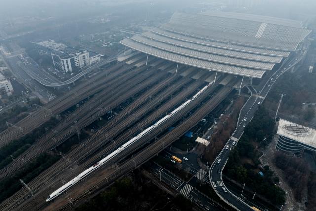 (260126) -- WUHAN, Jan. 26, 2026 (Xinhua) -- An aerial drone photo taken on Jan. 26, 2026 shows a train departing the Wuhan Railway Station in Wuhan, central China's Hubei Province. A new nationwide train schedule has taken effect in China from Jan. 26, 2026 with improved passenger and freight transport capacity and efficiency. (Xinhua/Wu Zhizun)