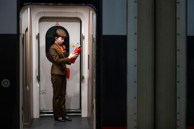 (260126) -- WUHAN, Jan. 26, 2026 (Xinhua) -- A train attendant checks fire extinguisher condition in a carriage of train No. G340 before departure at the Wuhan Railway Station in Wuhan, central China's Hubei Province, on Jan. 26, 2026. A new nationwide train schedule has taken effect in China from Jan. 26, 2026 with improved passenger and freight transport capacity and efficiency. (Xinhua/Wu Zhizun)