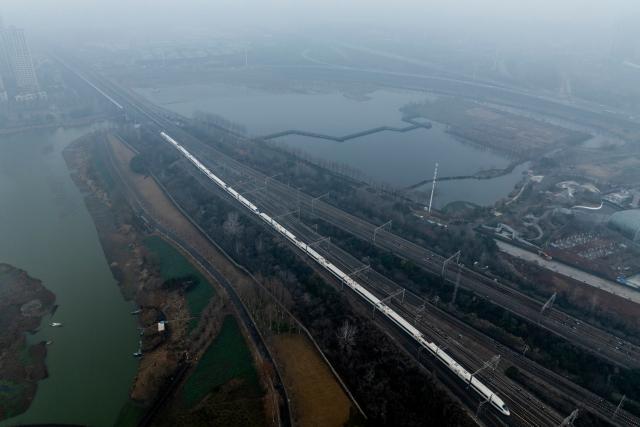 (260126) -- WUHAN, Jan. 26, 2026 (Xinhua) -- An aerial drone photo taken on Jan. 26, 2026 shows a train departing the Wuhan Railway Station in Wuhan, central China's Hubei Province. A new nationwide train schedule has taken effect in China from Jan. 26, 2026 with improved passenger and freight transport capacity and efficiency. (Xinhua/Wu Zhizun)
