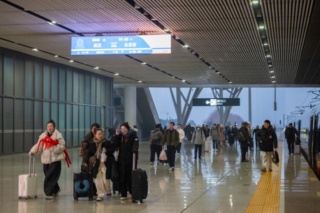 (260126) -- WUHAN, Jan. 26, 2026 (Xinhua) -- Passengers board train No. G340 at the Wuhan Railway Station in Wuhan, central China's Hubei Province, on Jan. 26, 2026. A new nationwide train schedule has taken effect in China from Jan. 26, 2026 with improved passenger and freight transport capacity and efficiency. (Xinhua/Wu Zhizun)