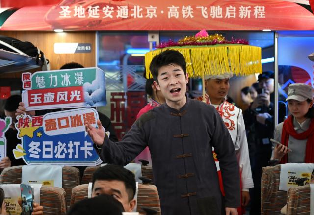 (260126) -- XI'AN, Jan. 26, 2026 (Xinhua) -- An actor sings folk songs on the high-speed train G359 from Yan'an, northwest China's Shaanxi Province to the capital city of Beijing, Jan. 26, 2026. The high-speed train G359 departed from Yan'an on Monday morning, marking the first direct connection of high-speed rail from the sacred revolutionary site to the nation's capital city of Beijing.
   The fastest high-speed train ride from Yan'an to Beijing will take five hours and 42 minutes, a big improvement compared to the original train. (Xinhua/Li Yibo)