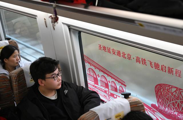 (260126) -- XI'AN, Jan. 26, 2026 (Xinhua) -- Passengers are seen on the high-speed train G359 from Yan'an, northwest China's Shaanxi Province to the capital city of Beijing, Jan. 26, 2026. The high-speed train G359 departed from Yan'an on Monday morning, marking the first direct connection of high-speed rail from the sacred revolutionary site to the nation's capital city of Beijing.
   The fastest high-speed train ride from Yan'an to Beijing will take five hours and 42 minutes, a big improvement compared to the original train. (Xinhua/Li Yibo)