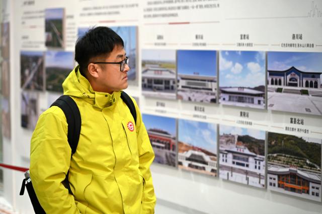 (260126) -- XI'AN, Jan. 26, 2026 (Xinhua) -- A passenger of the high-speed train G359 visits a photo exhibition on the high-speed railway construction at Yan'an Station in Yan'an, northwest China's Shaanxi Province, Jan. 26, 2026. The high-speed train G359 departed from Yan'an on Monday morning, marking the first direct connection of high-speed rail from the sacred revolutionary site to the nation's capital city of Beijing.
   The fastest high-speed train ride from Yan'an to Beijing will take five hours and 42 minutes, a big improvement compared to the original train. (Xinhua/Li Yibo)
