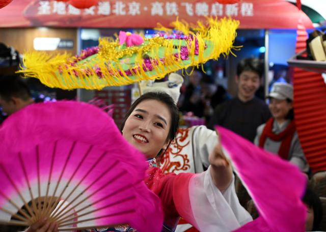 (260126) -- XI'AN, Jan. 26, 2026 (Xinhua) -- Actors perform the Yangko dance on the high-speed train G359 from Yan'an, northwest China's Shaanxi Province to the capital city of Beijing, Jan. 26, 2026. The high-speed train G359 departed from Yan'an on Monday morning, marking the first direct connection of high-speed rail from the sacred revolutionary site to the nation's capital city of Beijing.
   The fastest high-speed train ride from Yan'an to Beijing will take five hours and 42 minutes, a big improvement compared to the original train. (Xinhua/Li Yibo)