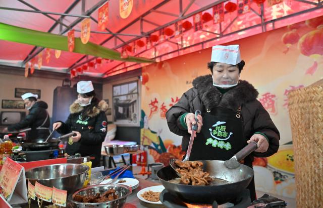 (260126) -- TIANJIN, Jan. 26, 2026 (Xinhua) -- Contestants attend a chef competition at an open air market during the Laba Festival in Tianjin, north China, Jan. 26, 2026. This year's Laba Festival falls on Monday, coinciding with the opening of the Lutai Market in Tianjin. The market features traditional activities such as free distribution of Laba porridge, calligraphy of the character "Fu" for blessings, and a village chef competition, attracting numerous residents from surrounding areas. (Xinhua/Sun Fanyue)