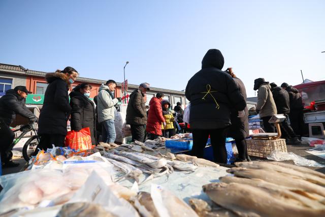 (260126) -- TIANJIN, Jan. 26, 2026 (Xinhua) -- People select products at an open air market during the Laba Festival in Tianjin, north China, Jan. 26, 2026. This year's Laba Festival falls on Monday, coinciding with the opening of the Lutai Market in Tianjin. The market features traditional activities such as free distribution of Laba porridge, calligraphy of the character "Fu" for blessings, and a village chef competition, attracting numerous residents from surrounding areas. (Xinhua/Sun Fanyue)
