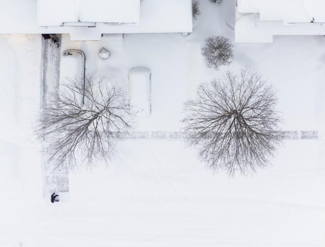 (260126) -- OAKVILLE, Jan. 26, 2026 (Xinhua) -- An aerial drone photo taken on Jan. 26, 2026 shows a resident clearing snow in Oakville, the Greater Toronto Area, Canada. (Photo by Zou Zheng/Xinhua)