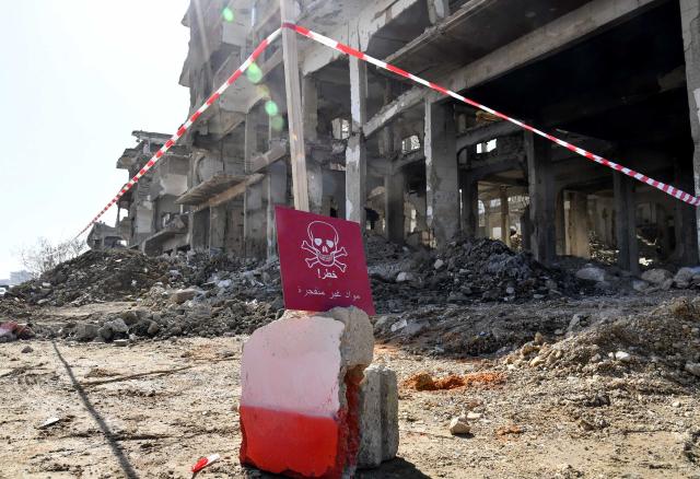(260126) -- DAMASCUS, Jan. 26, 2026 (Xinhua) -- A warning sign marks a damaged building cordoned off during a mine-clearance operation in the Jobar neighborhood of Damascus, Syria, Jan. 26, 2026, as part of coordinated efforts to remove explosive hazards, support reconstruction, and facilitate the return of residents after years of conflict. (Photo by Ammar Safarjalani/Xinhua)