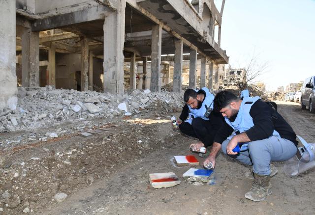 (260126) -- DAMASCUS, Jan. 26, 2026 (Xinhua) -- Members of Syria's Emergency and Disaster Management teams mark a cleared spot during a mine and unexploded ordnance survey in the Jobar neighborhood of Damascus, Syria, Jan. 26, 2026, as part of coordinated efforts to remove explosive hazards, support reconstruction, and facilitate the return of residents after years of conflict. (Photo by Ammar Safarjalani/Xinhua)
