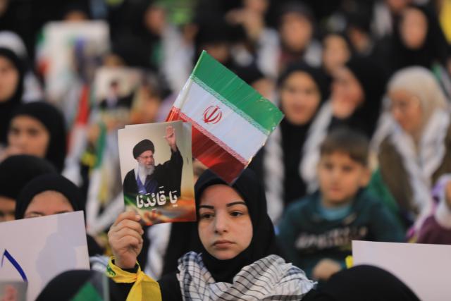 (260126) -- BEIRUT, Jan. 26, 2026 (Xinhua) -- Photo taken on Jan. 26, 2026 shows Hezbollah supporters holding portraits of Iranian Supreme Leader Ali Khamenei and waving Iranian flags during a rally to voice support for Iran and denounce U.S. threats in Beirut, Lebanon. (Photo by Bilal Jawich/Xinhua)