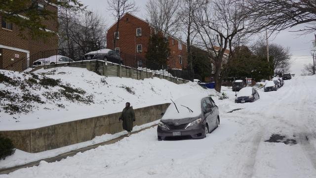 (260126) -- ARLINGTON COUNTY, Jan. 26, 2026 (Xinhua) -- A woman walks past snow-covered vehicles in Arlington County, Virginia, the United States, on Jan. 26, 2026. (Xinhua/Xu Jianmei)