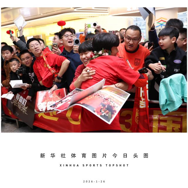 (260126) -- BEIJING, Jan. 26, 2026 (Xinhua) -- Kuai Jiwen (front) of Chinese U23 men's football team hugs fans at Beijing Daxing International Airport in Beijing, China, Jan. 26, 2026. Team China, which finished as runner-up at the AFC U23 Asian Cup in Saudi Arabia, arrived in Beijing on Monday. (Xinhua/Luo Yuan)