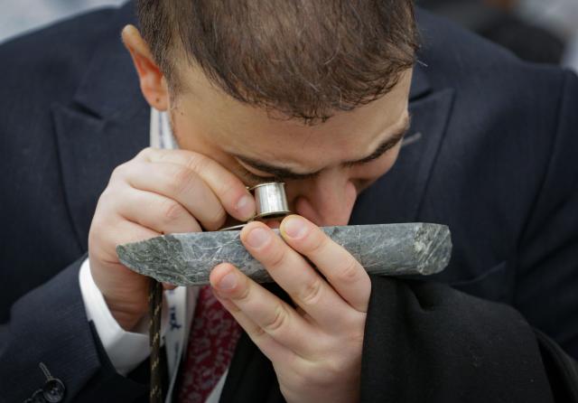 (260127) -- VANCOUVER, Jan. 27, 2026 (Xinhua) -- An attendee examines a mineral rock sample with magnifier during the Association for Mineral Exploration (AME) Roundup 2026 at the Vancouver Convention Centre in Vancouver, British Columbia, Canada, on Jan. 26, 2026. The AME Roundup 2026 kicked off here on Monday, featuring a four-day exhibition with exhibitors from around the world showcasing products, technologies and services related to mineral exploration and development. The event runs from Jan. 26 to Jan. 29. (Photo by Liang Sen/Xinhua)