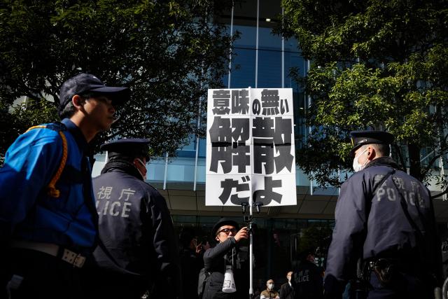 (260127) -- TOKYO, Jan. 27, 2026 (Xinhua) -- A protester holds a sign during a campaign event of Japanese Prime Minister Sanae Takaichi in Tokyo, Japan, on Jan. 27, 2026. Campaigning for Japan's Feb. 8 snap general election officially kicked off across the country on Tuesday with all 465 seats in the House of Representatives up for contest. Of the 465 lower house seats, 289 will be elected from single-member districts and 176 through proportional representation in 11 regional blocs. National broadcaster NHK said more than 1,200 candidates are expected to run. National broadcaster NHK said more than 1,200 candidates are expected to run. (Xinhua/Jia Haocheng)