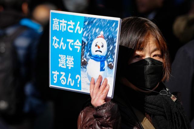 (260127) -- TOKYO, Jan. 27, 2026 (Xinhua) -- A protester holds a sign during a campaign event of Japanese Prime Minister Sanae Takaichi in Tokyo, Japan, on Jan. 27, 2026. Campaigning for Japan's Feb. 8 snap general election officially kicked off across the country on Tuesday with all 465 seats in the House of Representatives up for contest. Of the 465 lower house seats, 289 will be elected from single-member districts and 176 through proportional representation in 11 regional blocs. National broadcaster NHK said more than 1,200 candidates are expected to run. National broadcaster NHK said more than 1,200 candidates are expected to run. (Xinhua/Jia Haocheng)