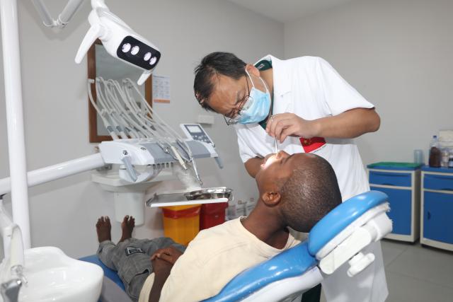 (260127) -- ZANZIBAR, Jan. 27, 2026 (Xinhua) -- Xu Wei (L), a Chinese oral and maxillofacial surgery specialist, checks a patient's post-operative recovery in Zanzibar, Tanzania, on Dec. 17, 2025. TO GO WITH "Feature: Chinese doctors restore smile, hope for Zanzibar teen through life-changing surgery" (The 35th Chinese medical team in Zanzibar/Handout via Xinhua)
