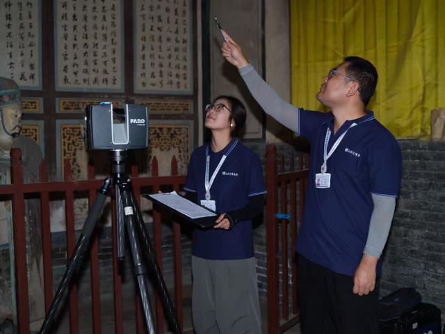 (260127) -- TAIYUAN, Jan. 27, 2026 (Xinhua) -- Digital scanner Jia Zhi (R) works with a colleague in an ancient building in Pingyao County, north China's Shanxi Province, on Aug. 19, 2025. TO GO WITH "China Focus: Digital preservation safeguards, promotes timeless beauty of China's ancient relics" (Xinhua)