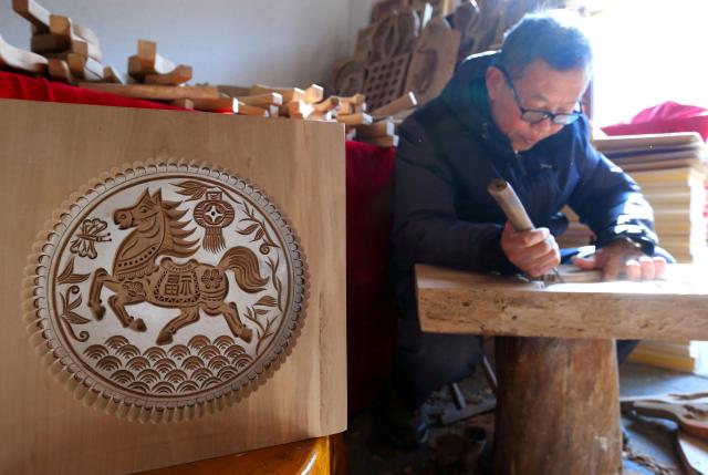 (260127) -- JI'NAN, Jan. 27, 2026 (Xinhua) -- A craftsman makes horse-themed wood handicraft in Jimo District of Qingdao, east China's Shandong Province, on Jan. 17, 2026. With the Year of the Horse approaching, a wide range of horse-themed cultural products, from museum souvenirs to traditional crafts, are gaining popularity in east China's Shandong Province. (Photo by Liang Xiaopeng/Xinhua)