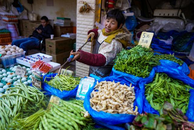 (260127) -- KUNMING, Jan. 27, 2026 (Xinhua) -- A vendor sprays water on vegetables to keep them fresh at Daguan Zhuanxin farmers' market in Kunming, southwest China's Yunnan Province, Jan. 27, 2026. While preserving the original function of a farmers' market, Daguan Zhuanxin farmers' market has now been upgraded to a complex of cultural experience, dining and entertainment, which offers tourists a window to experience local flavor and vibe. (Xinhua/Chen Xinbo)